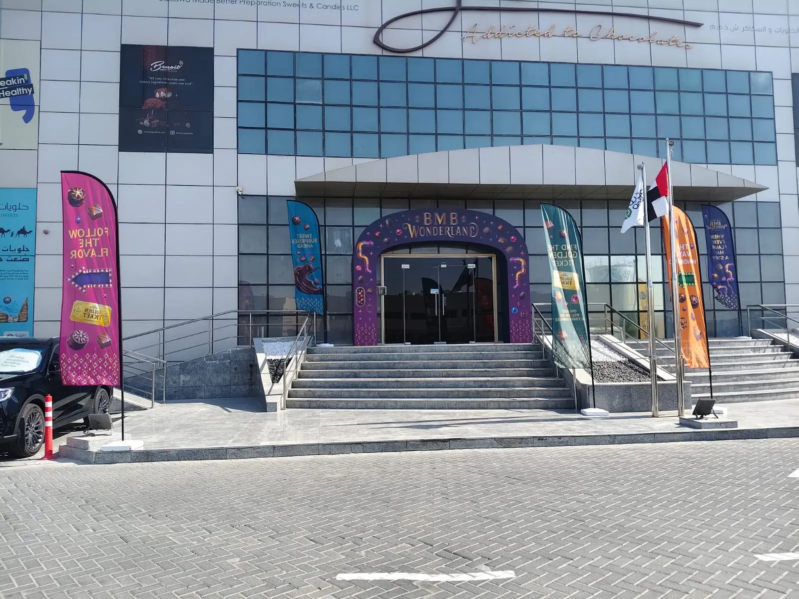 Office building entrance dressed with a purple arch and rows of feather flags