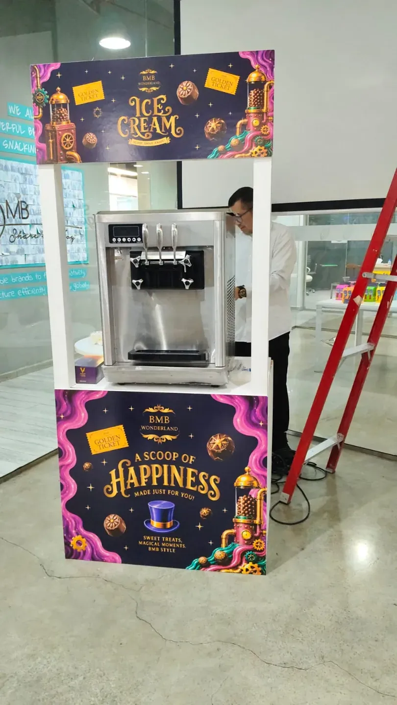 Branded soft-serve cart in purple and gold being set up in an office atrium