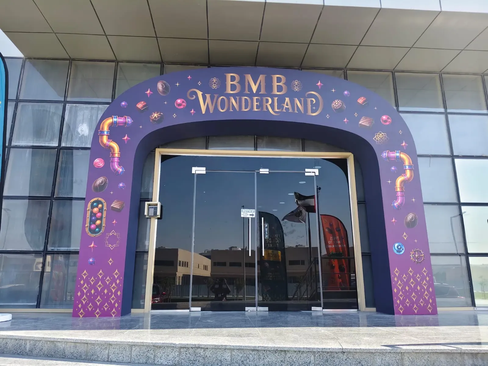 Purple decorated arch built around the glass entrance doors of an office building