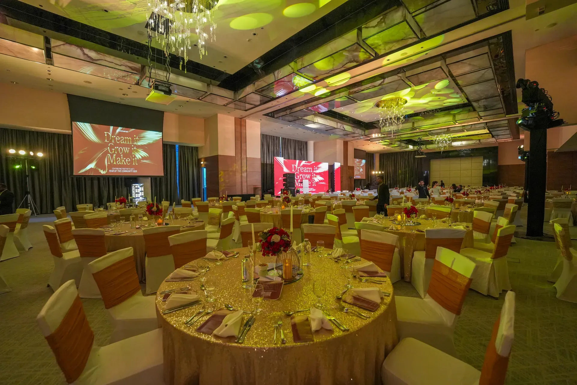 Close view of a gold banquet round with burgundy napkins and a red rose centrepiece
