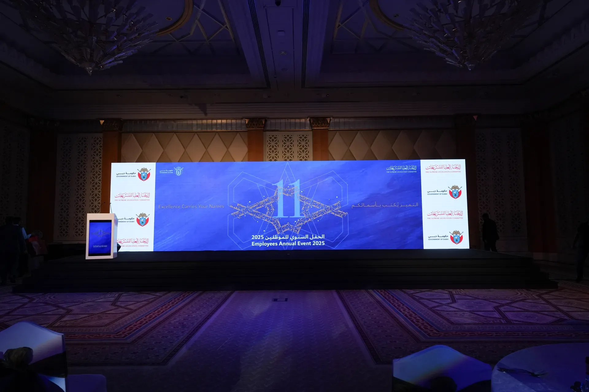 Wide LED stage screen carrying an employee annual event graphic above an empty floor