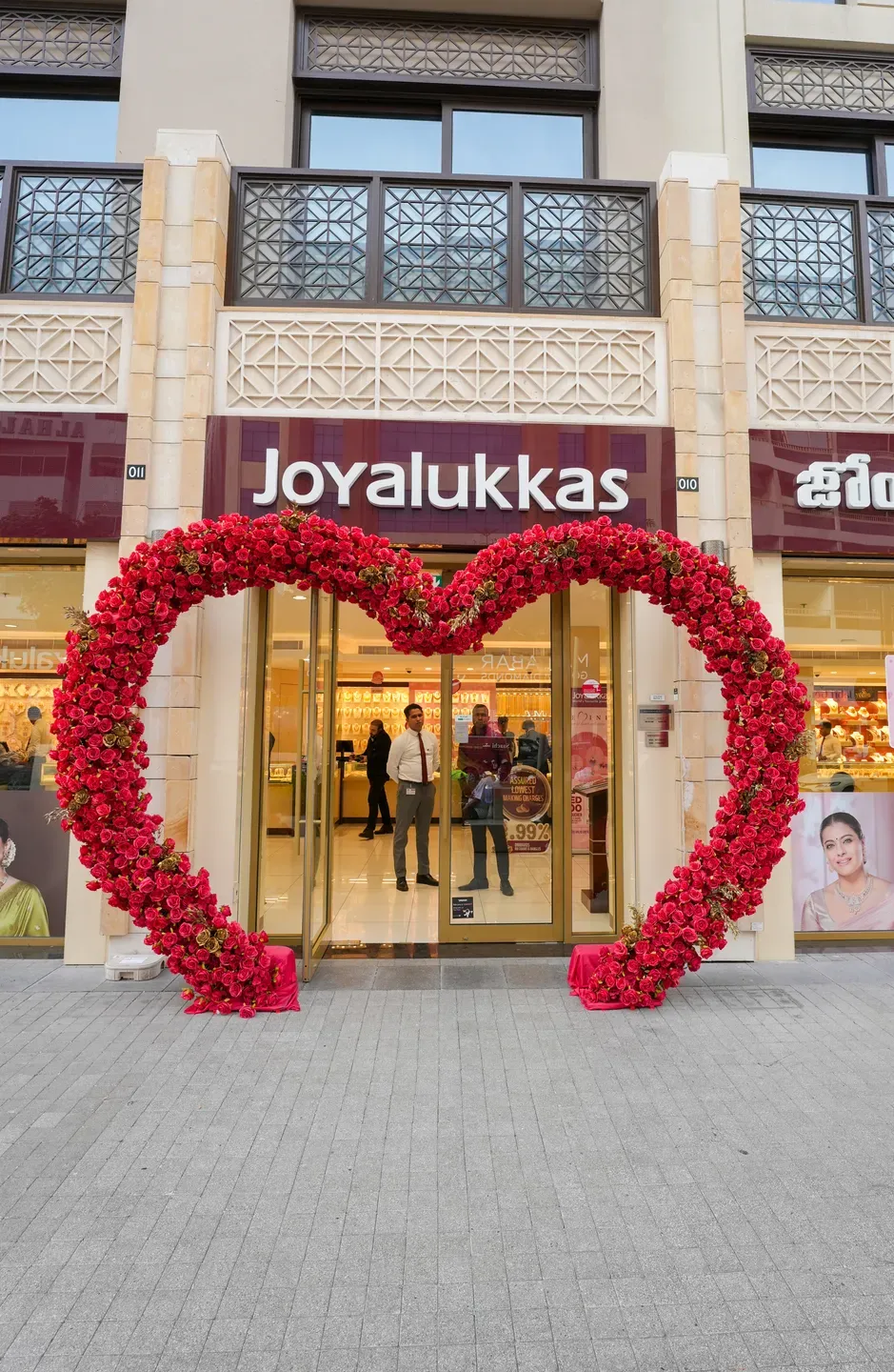 Heart-shaped arch of red roses framing a jewellery store entrance on a street
