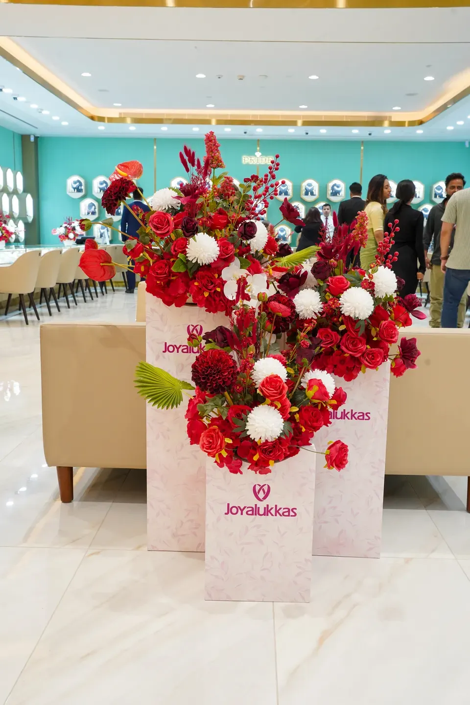 Three branded floral plinths in red and white inside a jewellery showroom