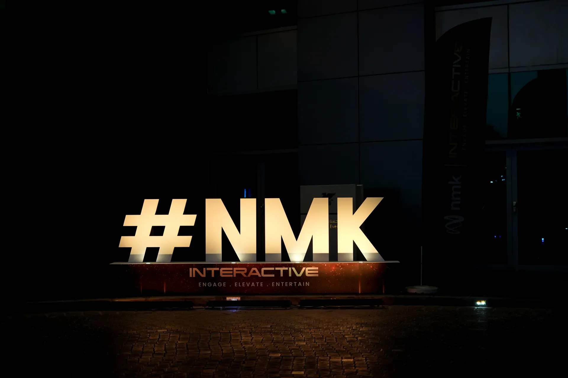 Large illuminated hashtag letters standing outside a building at night