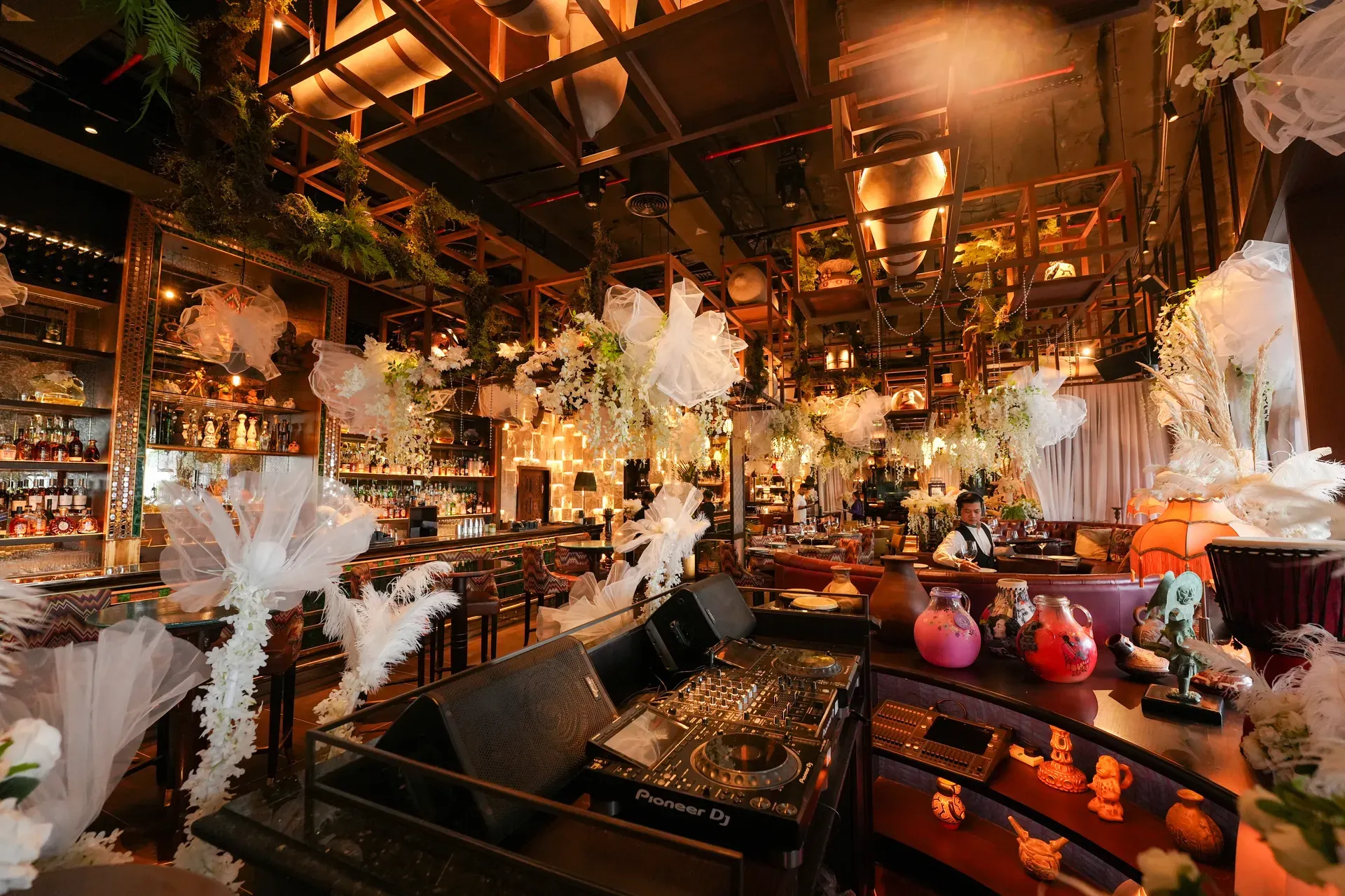 Two-storey restaurant with tulle and floral installations across both levels