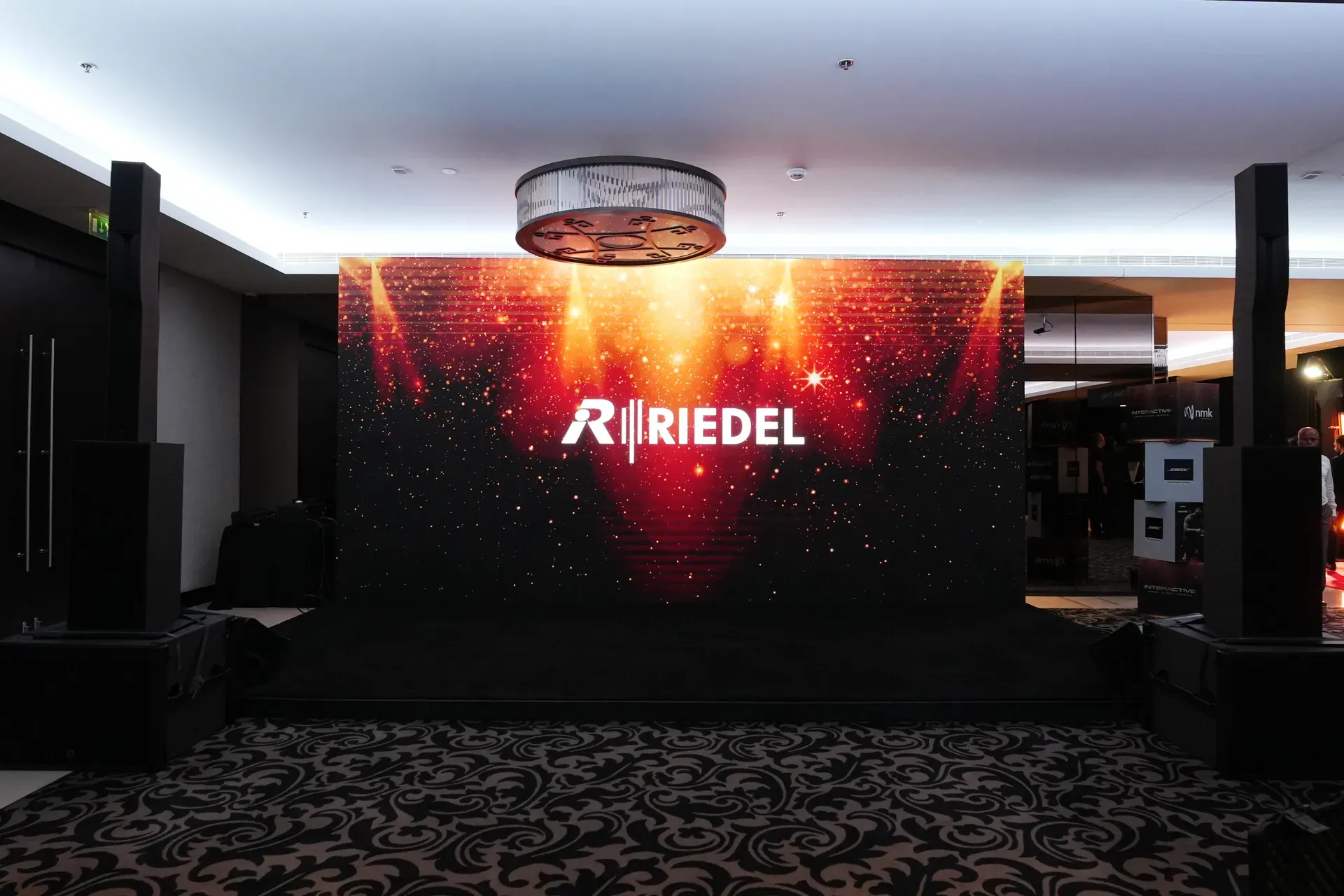 Freestanding LED wall showing a red graphic in a carpeted hotel foyer