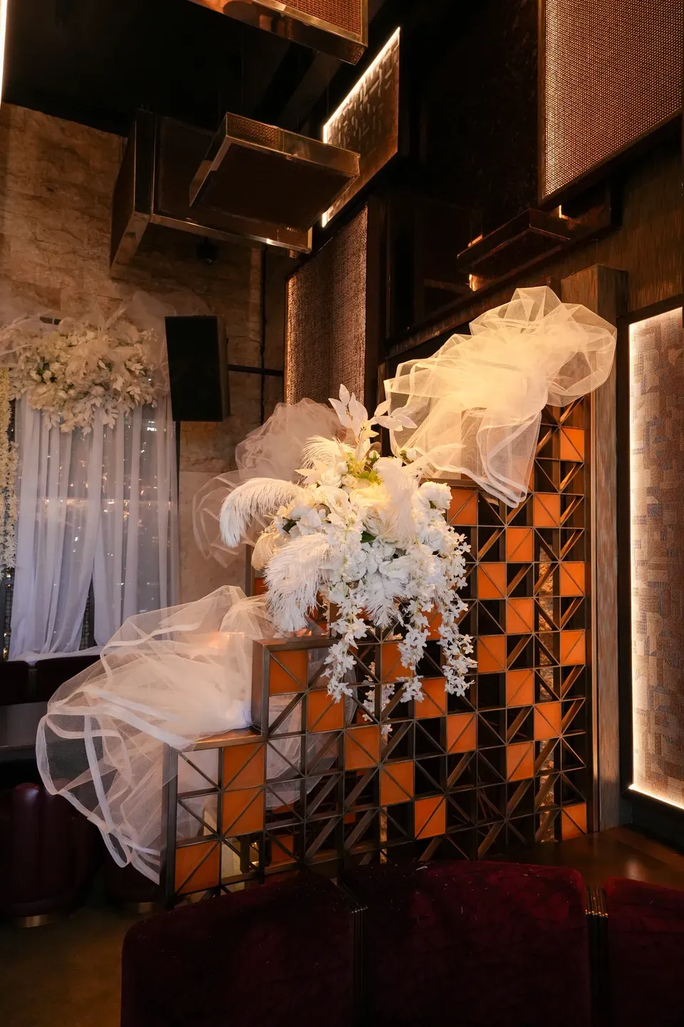 White florals and tulle trailing down a tiled staircase wall in a dim interior